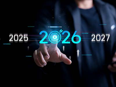 Empresario señalando el año 2026 iluminado en azul con flechas ascendentes sobre fondo oscuro, representando objetivos empresariales